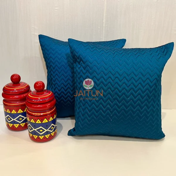 Pair of Azure Comfort Chevron Cushions in blue, styled with colorful decorative jars