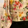 Back sleeve view of Blossom Elegance Floral Blouse featuring colorful floral motifs and pleated design