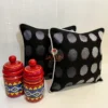 Decorative styled shot of Eclipse Polka Dot Cushion Covers, set of two in black and silver with jars