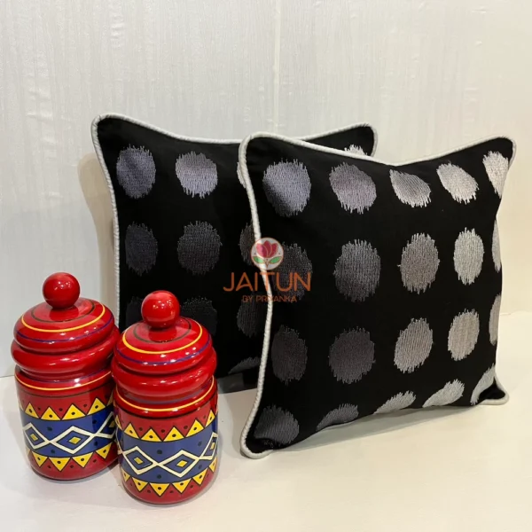 Decorative styled shot of Eclipse Polka Dot Cushion Covers, set of two in black and silver with jars