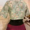 Back view of Elegant Blossom Embroidered Crop Top Blouse showing pastel blue floral pattern and short sleeves