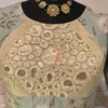 Closeup of Elegant Blossom Embroidered Crop Top Blouse with golden threadwork and pastel blue floral fabric