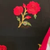 Intricate pink and red floral embroidery on black fabric of Floral Fantasy Ruffle Sleeve Crop Blouse