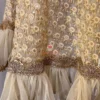 Hemline detail of Golden Grace Embellished A-Line Kurta showing intricate gold embroidery, layered frills, and premium craftsmanship for festive Kurti & Dress ensembles.