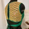 Angled back image of teal green silk blouse showing golden wave embroidery and tie closure