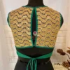 Back view of teal green silk blouse featuring open back and full golden embroidered design