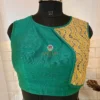 Closeup of golden embroidered wave panel on teal green silk blouse, highlighting luxe craftsmanship