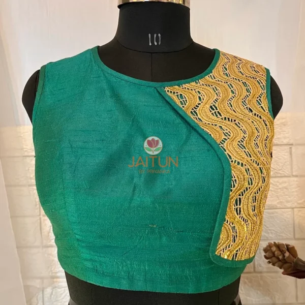 Closeup of golden embroidered wave panel on teal green silk blouse, highlighting luxe craftsmanship