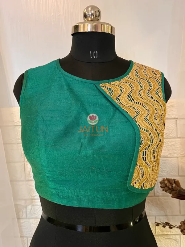 Closeup of golden embroidered wave panel on teal green silk blouse, highlighting luxe craftsmanship