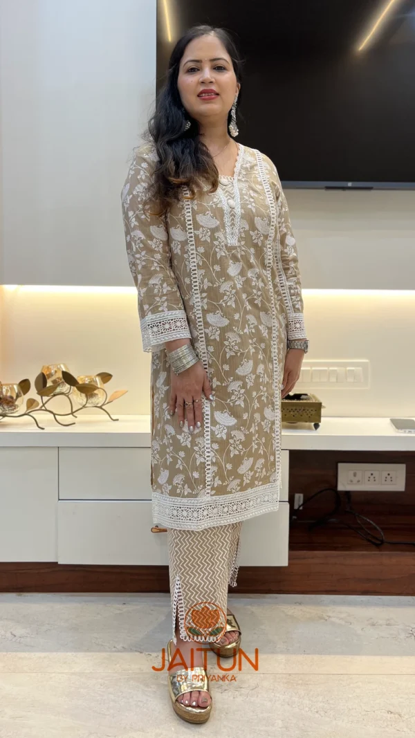 Close-up of sleeve on beige floral embroidered kurta suit with pant, showing detailed lace and floral embroidery