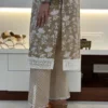 Close-up of pant hem on beige floral embroidered kurta suit, focusing on lace and chevron print detailing
