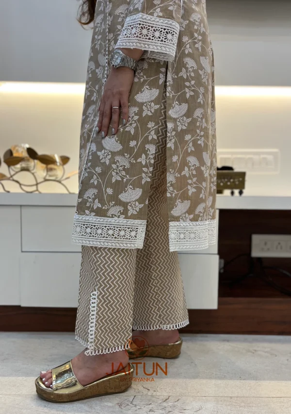 Close-up of pant hem on beige floral embroidered kurta suit, focusing on lace and chevron print detailing