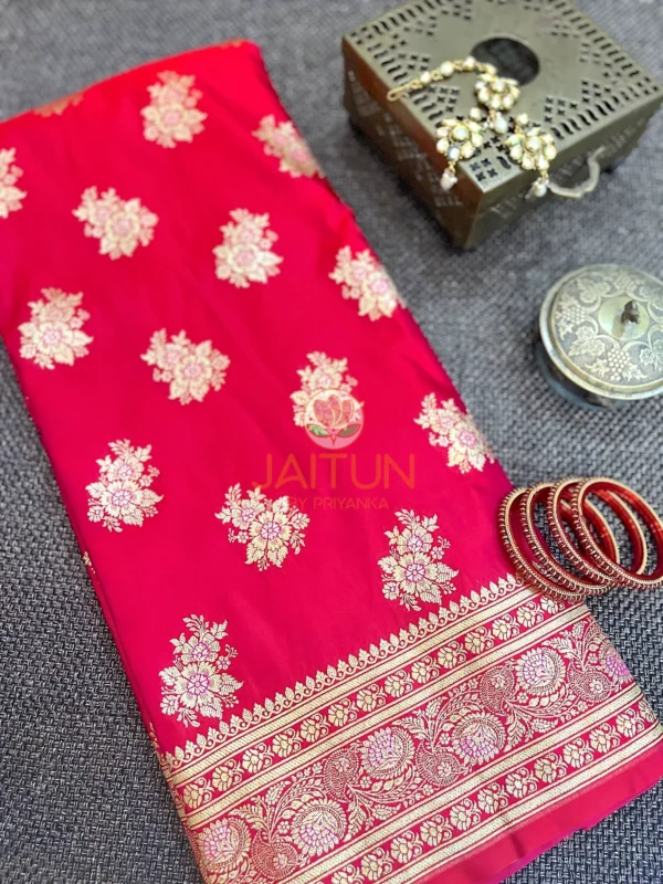 Crimson Bloom Banarasi Silk Saree flatlay with gold floral motifs and intricate zari border, paired with red bangles and traditional jewelry