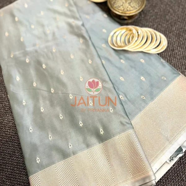Elegant Grey Banarasi Silk Saree displayed with matching gold bangles and vintage box, showcasing refined zari work and soft sheen
