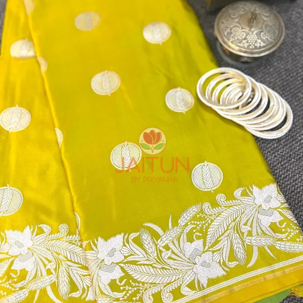 Lime Green Banarasi Silk Saree flatlay with silver zari floral border, circular motifs, and white bangles for traditional styling