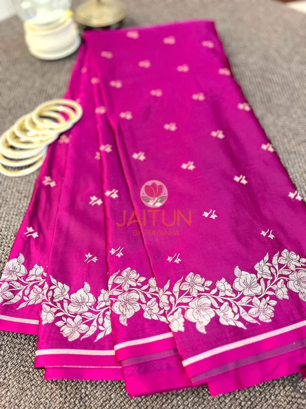 Magenta Grace Banarasi Silk Saree flatlay featuring intricate silver floral border, delicate silk texture, and white bangles