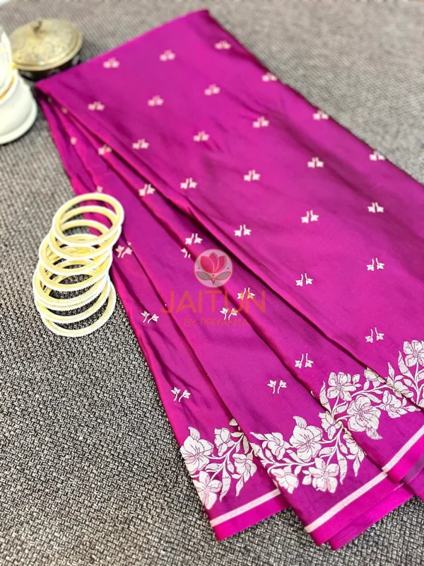 Magenta Grace Banarasi Silk Saree styled with white bangles and brass decor, highlighting ornate border and elegant craftsmanship