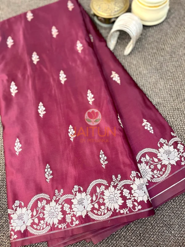 Mulberry Grace Silk Saree flatlay with white floral embroidery and ornate border, styled with silver bangles and brass decor