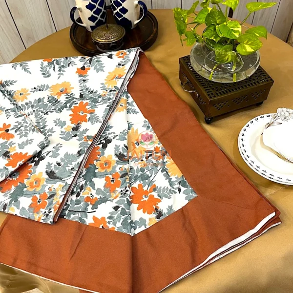 Corner display of Amber Floral Bloom bed sheet set with leafy floral pattern and rust brown border