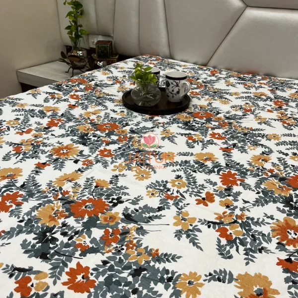 Decor view of Amber Floral Bloom bed sheet set on bed with mugs and green plant, featuring vibrant floral pattern