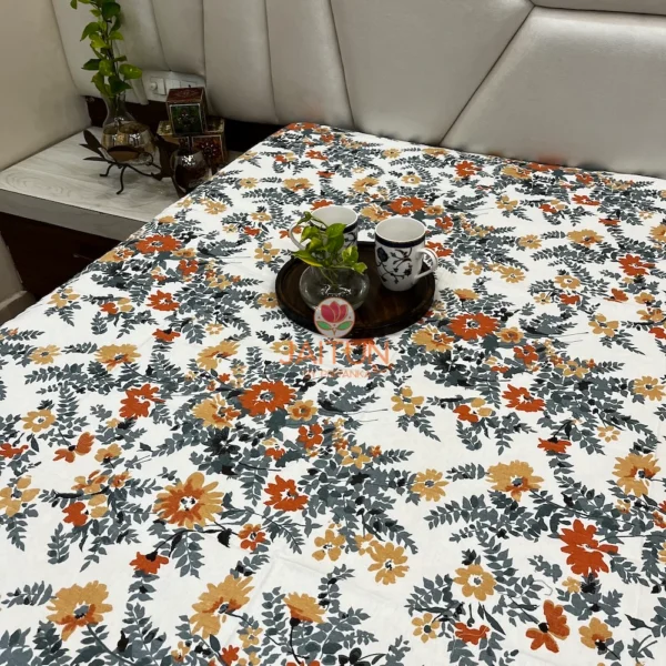 Room view of Amber Floral Bloom bed sheet set styled with tableware and leafy floral design in bedroom