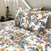 Closeup of Autumn Garden Bloom bed sheet set arranged on bed, focusing on vibrant flower and leaf design