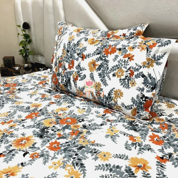 Closeup of Autumn Garden Bloom bed sheet set arranged on bed, focusing on vibrant flower and leaf design