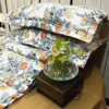 Autumn Garden Bloom bed sheet set displayed with green plant decor, highlighting orange and yellow floral print