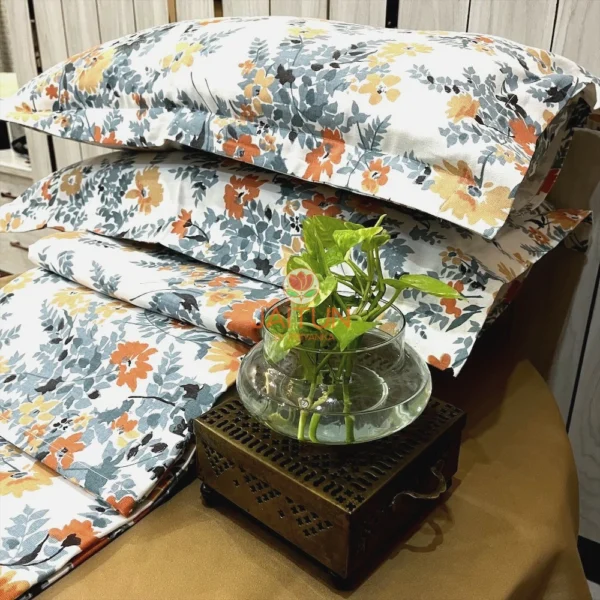 Autumn Garden Bloom bed sheet set displayed with green plant decor, highlighting orange and yellow floral print