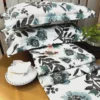 Azure Bloom Botanical Cotton Bedsheet Set displayed with green plant decor and elegant tableware, highlighting botanical pattern.