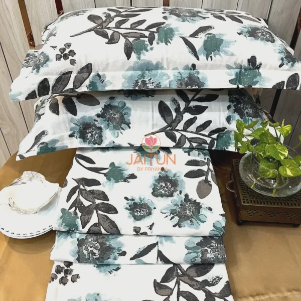 Stacked view of Azure Bloom Botanical Cotton Bedsheet Set featuring blue and grey floral prints with matching pillow covers.