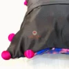 Back view of Birdsong Jungle embroidered cushion cover with button closure and pink pompoms