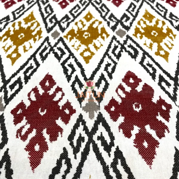 Closeup of Ikat Harmony bed sheet pattern with rich maroon, mustard, grey, and red ikat motifs for a textured effect.
