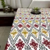Room view of Ikat Harmony bed sheet showcasing bold maroon borders and vibrant ikat print across the full bed.