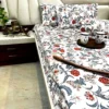 Royal Crimson Bloom cotton bed sheet set with bold floral print spread on the bed, complemented by pillows and decorative cup tray.