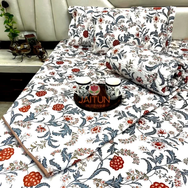 Royal Crimson Bloom cotton bed sheet set elegantly displayed on the bed with matching pillows and rolled quilt, styled with serving cups.