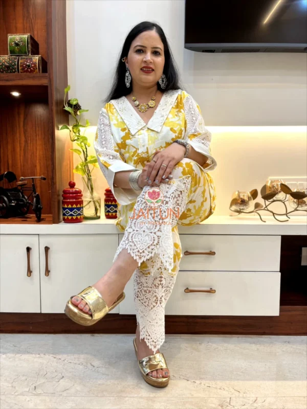 Sunlit Grace Co-ord Set styled in a seated pose, featuring golden yellow floral prints and white lace pants