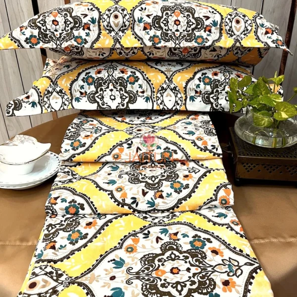 Sunshine Elegance Yellow Bloom bed sheet set with stacked pillows featuring intricate floral and paisley patterns in yellow, white, and brown.