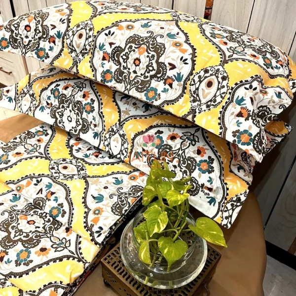 Close-up of Sunshine Elegance Yellow Bloom bed sheet showing vibrant floral and paisley motifs in yellow and white with decorative pillows.