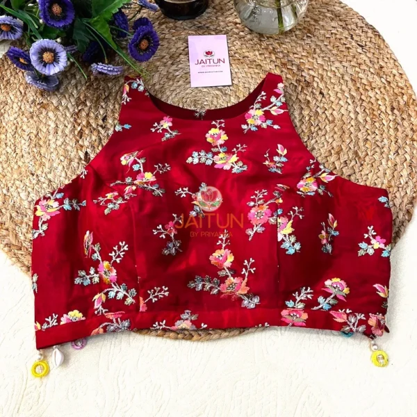 Front view of Crimson Bloom Hand-Embroidered Wedding Blouse showcasing vibrant multicolour floral embroidery on rich crimson silk, adorned with festive beads and pearl drops along the hemline