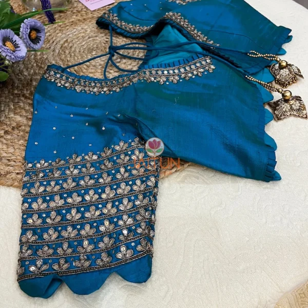Focus on the peplum edge of Royal Blue Kundan Silk Blouse with scalloped hem and kundan embroidery, suitable for wedding functions.