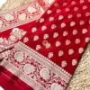 Close view of maroon Banarasi silk saree featuring intricate antique gold zari floral border and hand-woven motifs