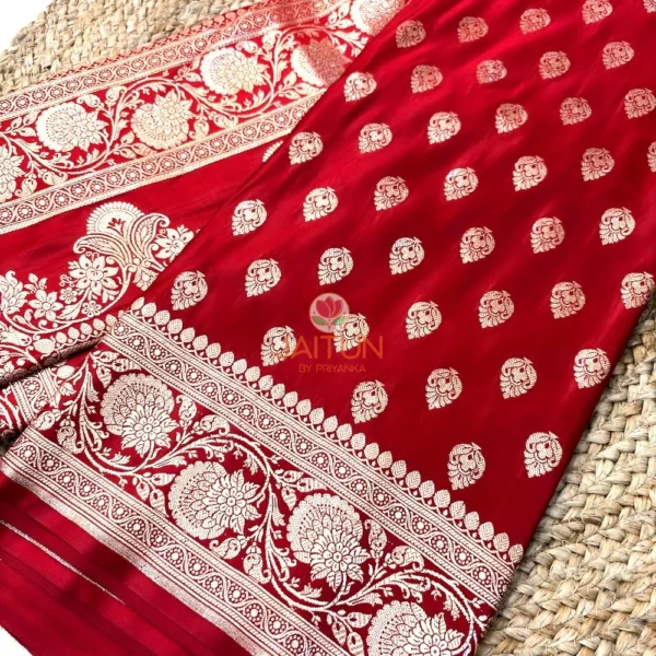 Close view of maroon Banarasi silk saree featuring intricate antique gold zari floral border and hand-woven motifs