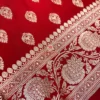 Red Banarasi silk saree flatlay showing rich antique gold zari work and traditional motifs, perfect for festive events