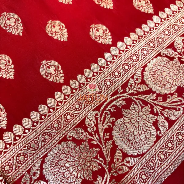 Red Banarasi silk saree flatlay showing rich antique gold zari work and traditional motifs, perfect for festive events