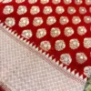 Regal Red Pure Banarasi Silk Saree closeup with golden zari boota and temple border Closeup of Regal Red Pure Banarasi Silk Saree showing golden zari boota with intricate temple edge and diamond weave border
