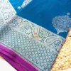 Teal blue pure Banarasi silk saree with silver zari border, pallu detailing, and butidar pattern.