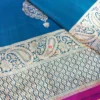 Close-up of teal blue pure Banarasi silk saree with silver zari paisley border and butidar weave.