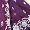 Close-up of deep wine Banarasi silk saree with silver zari floral border and woven detailing.