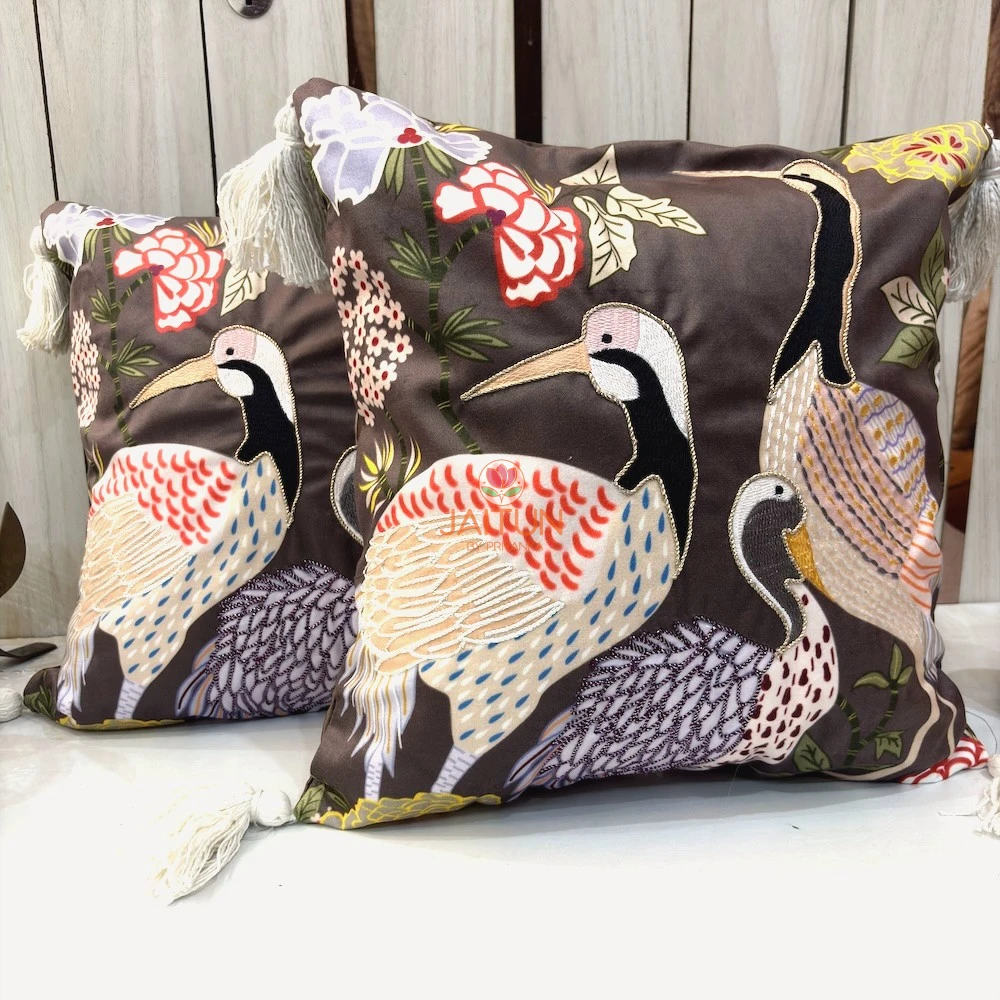 Close-up of embroidered crane bird design on Crane Garden Cushion Cover with botanical floral accents and tassel corners.